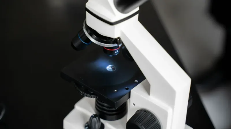 Vista de cerca de un microscopio de laboratorio con enfoque selectivo, ideal para uso científico.