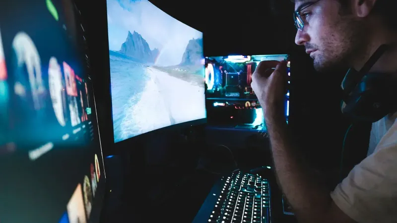 Un hombre con anteojos se centró en múltiples pantallas, mostrando la configuración de la tecnología moderna.