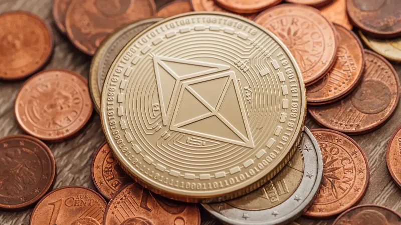 Primer plano de una moneda Ethereum física en un montón de monedas fiat.