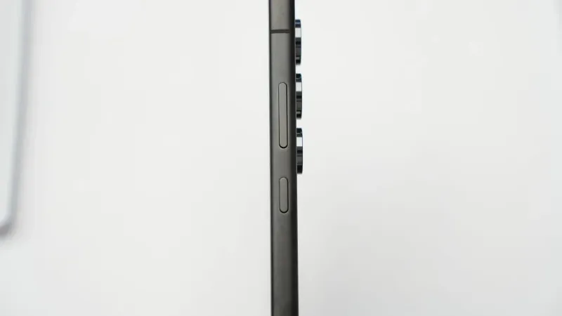 Disparo de perfil lateral minimalista de un smartphone delgado moderno que destaca sus lentes de cámara.