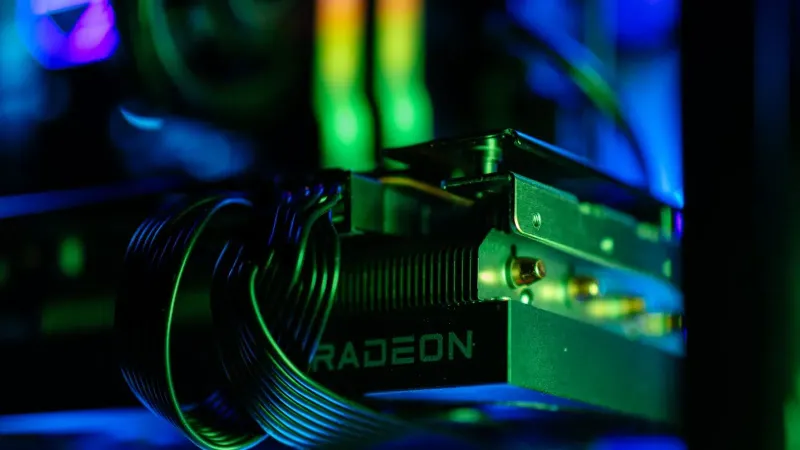 Primer plano detallado de la tarjeta gráfica Radeon de una PC para juegos con iluminación RGB vibrante, cables y hardware.