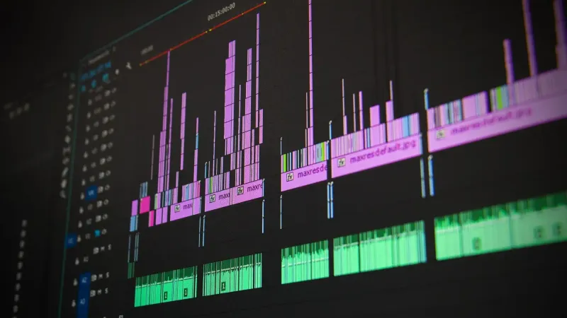 Primer plano de una interfaz de software de edición de audio y video profesional con pantallas de forma de onda.