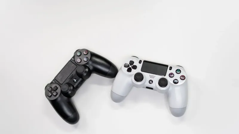 Lay Flat de controladores de juegos en blanco y negro contra un fondo blanco, perfecto para los entusiastas de los juegos.