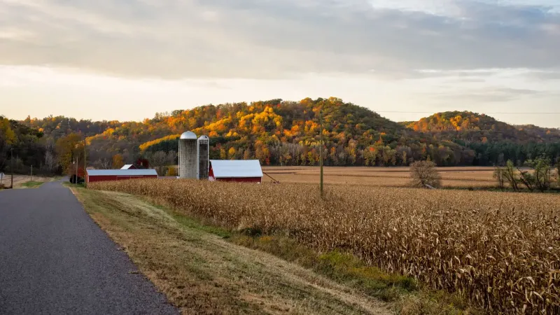 Vista pintoresca de una granja con silos y follaje de otoño en Ella, Wisconsin.