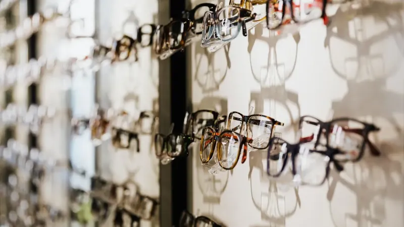 Pantalla de pared de diversos anteojos en un entorno de tienda con elegantes sombras.