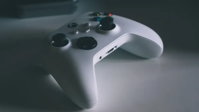 A detailed shot of a white gaming controller on a desk surface, perfect for tech and gaming themes.
