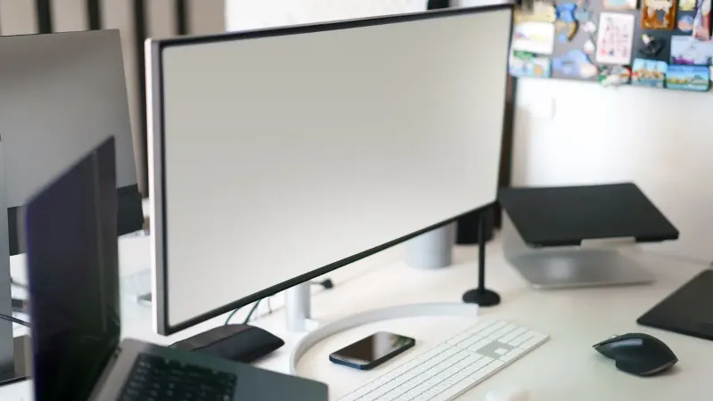 Espacio de trabajo de oficina limpio y moderno con una configuración de escritorio con un monitor grande y accesorios.