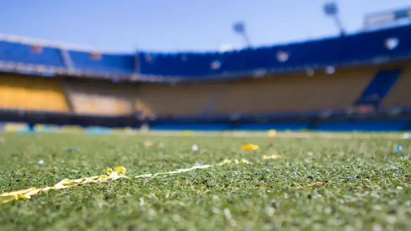 Close-up view of a vibrant football pitch in a sunlit Buenos Aires stadium, perfect for sports enthusiasts.