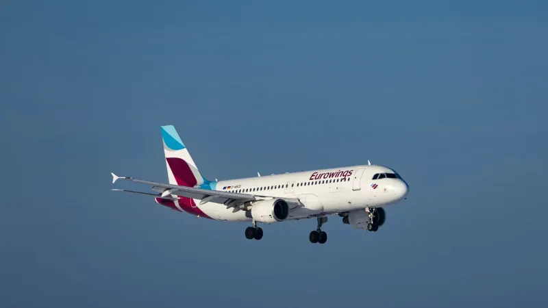 Un avión de Eurowings capturó a mitad de vuelo contra un cielo azul despejado, mostrando la dinámica de la aviación.