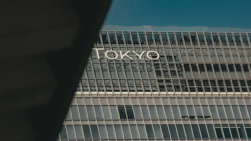 Una vista de un edificio moderno en Tokio con vidrio reflectante y arquitectura urbana.