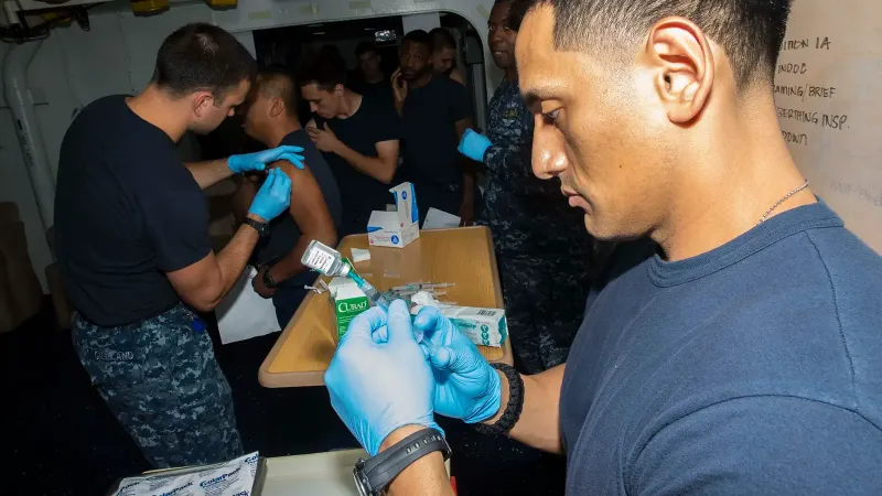 Hospital Corpsman 2nd Class Albert Delacruz fills a syringe with the flu vaccine in the medical department aboard the amphibious assault ship USS Boxer (LHD 4).