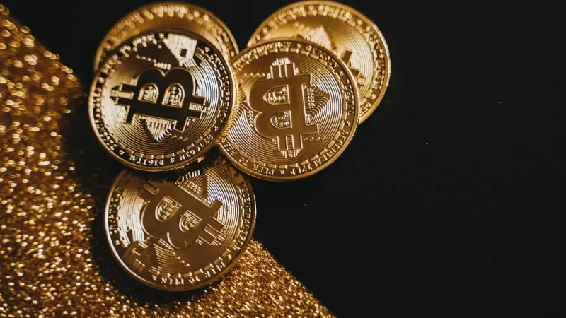 A detailed close-up shot of shiny bitcoin coins resting on a glittery surface, symbolizing wealth in digital currency.