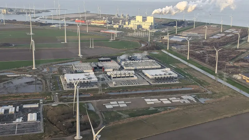 Aerial view of the Google data center at Eemshaven, Netherlands, surrounded by wind turbines with a power plant in the background