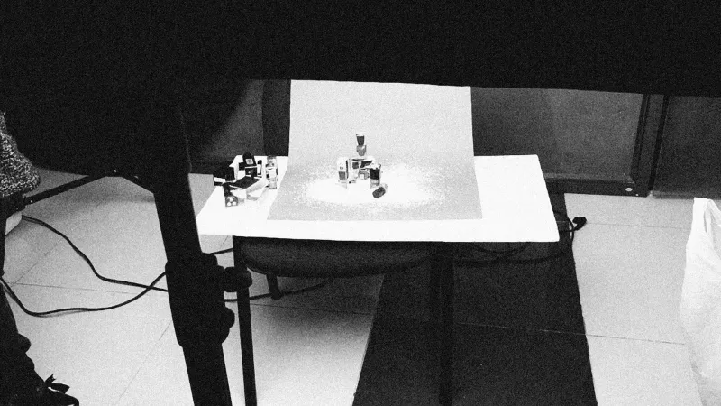 Configuración de estudio en blanco y negro con cosméticos en la mesa para sesión de fotos del producto.