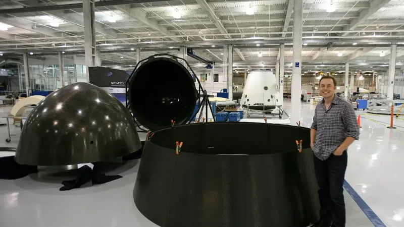 Varios componentes de la cápsula SpaceX Dragon en un estado de desmontaje, con Elon Musk esperando.