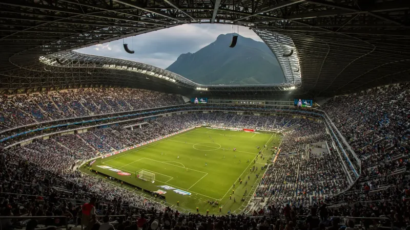 Un vibrante partido de fútbol en el Estadio BBVA con un telón de fondo de Cerro de la Silla, Monterrey.