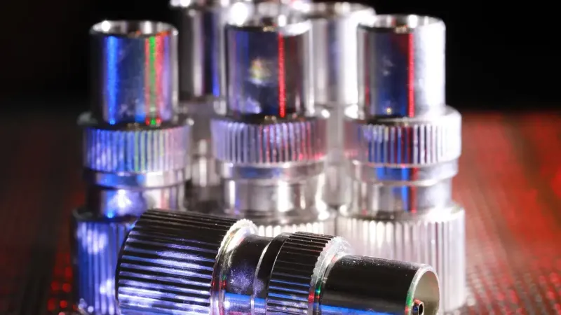Vista detallada de conectores metálicos con iluminación dramática creando una sensación industrial.