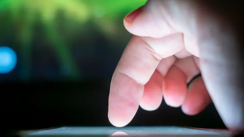 Primer plano de un dedo interactuando con una pantalla táctil, capturando un momento de uso de la tecnología.