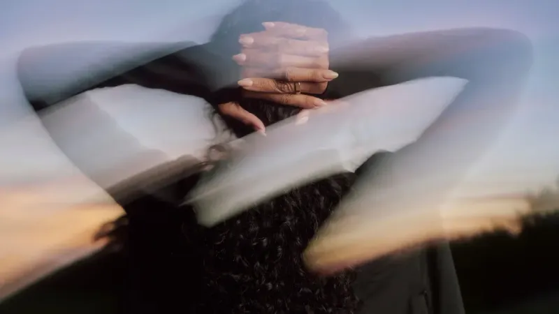 Mujer usando Oura Ring 5 con las manos en la cabeza después de un entrenamiento
