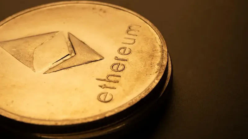 Detailed macro shot of an Ethereum logo coin against a dark background.