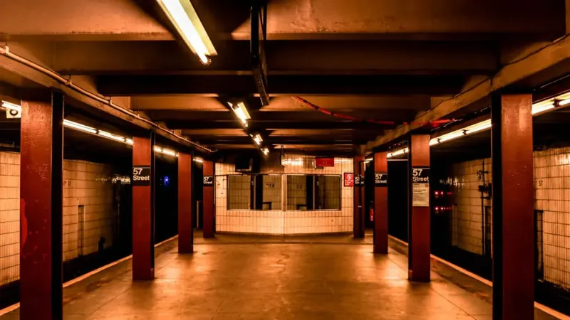Una plataforma de metro desierta en la estación de 57th Street, Nueva York, que muestra la arquitectura urbana.
