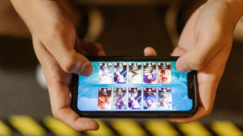 Close-up de manos jugando un juego móvil en un smartphone, mostrando la interfaz del juego.