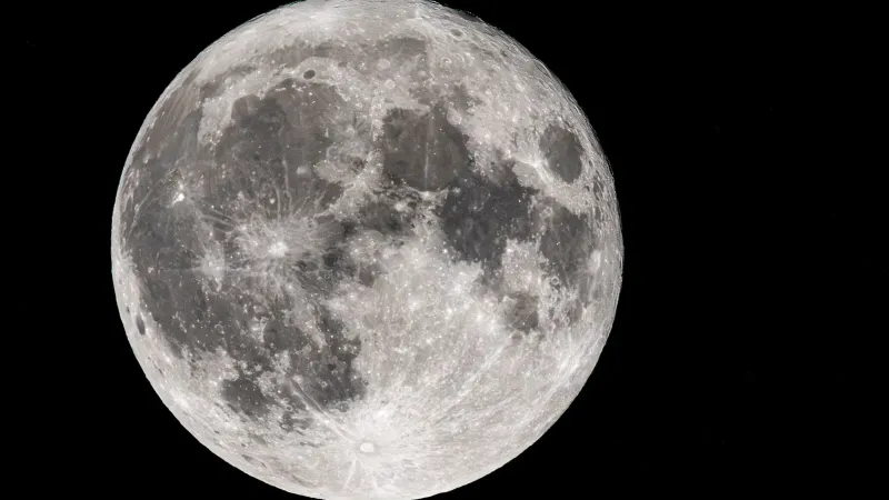 Imagen de primer plano de la luna llena que captura características de superficie detalladas contra un cielo nocturno negro.