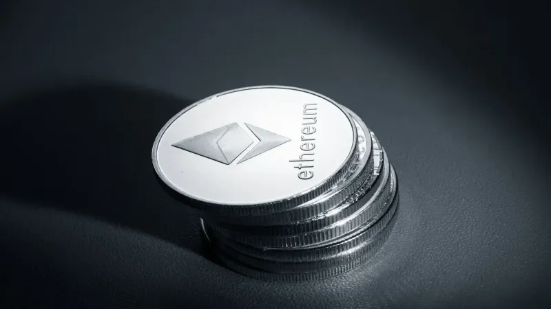 Close-up of stacked Ethereum coins on a dark textured surface, symbolizing modern cryptocurrency.