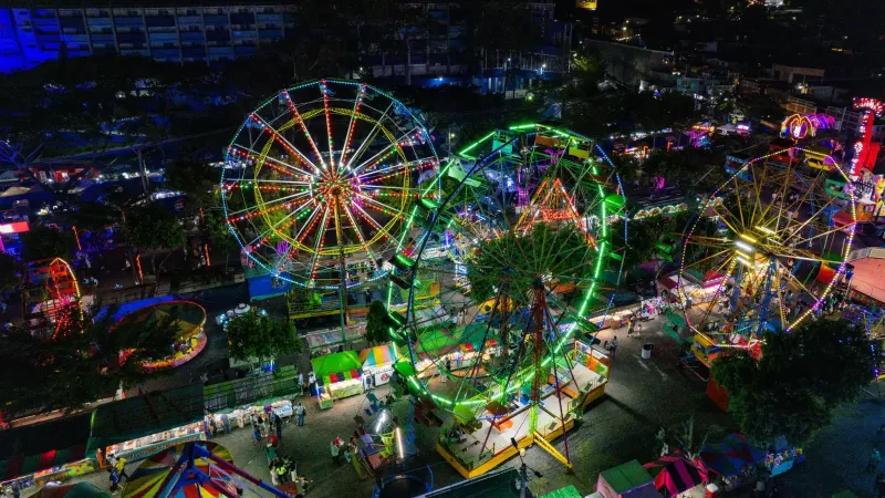 A vibrant aerial view of an amusement park at night in San Salvador, El Salvador.