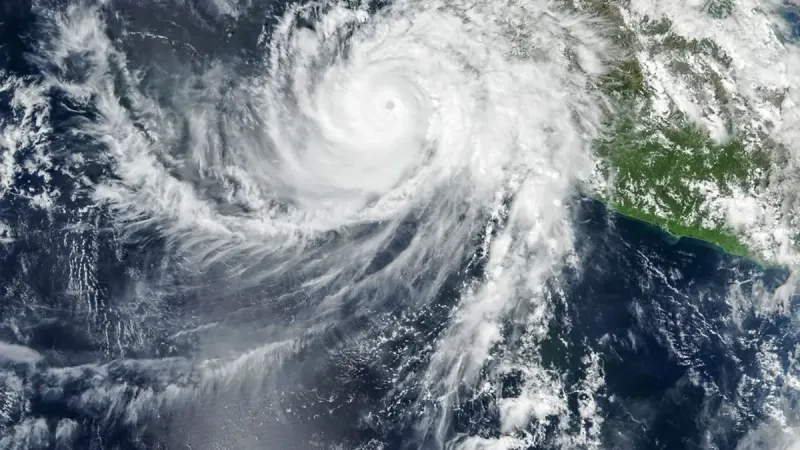 El ojo bien definido del huracán Simon se encuentra justo al lado de la costa del Pacífico de México. Algunas bandas de nubes externas de la tormenta en espiral se extienden sobre la tierra.