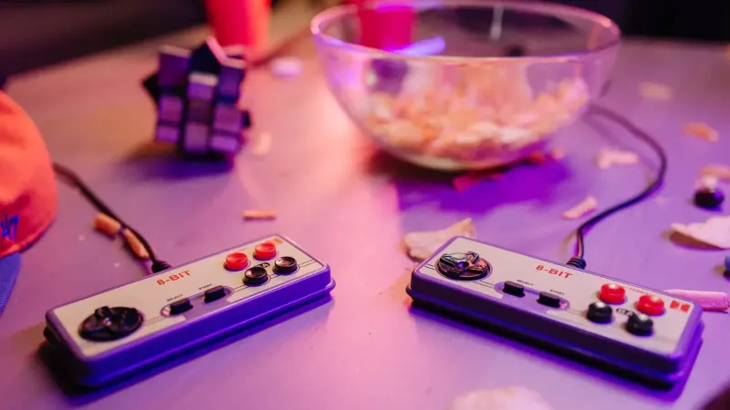 Retro gaming scene featuring classic 8-bit controllers and a relaxed setting with snacks.