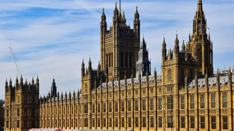 Impresionante vista del palacio histórico de Westminster en Londres bajo un cielo azul claro.