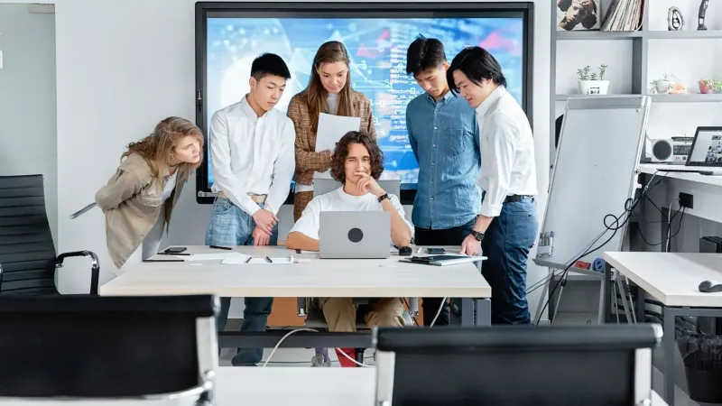 Diverso equipo colaborando en un proyecto de software en un entorno de oficina contemporáneo.