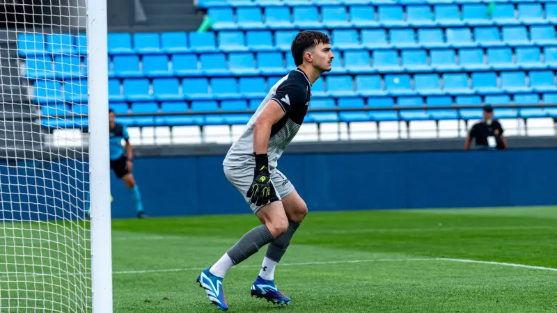 Portero en acción durante un partido de fútbol, listo para defender la portería.
