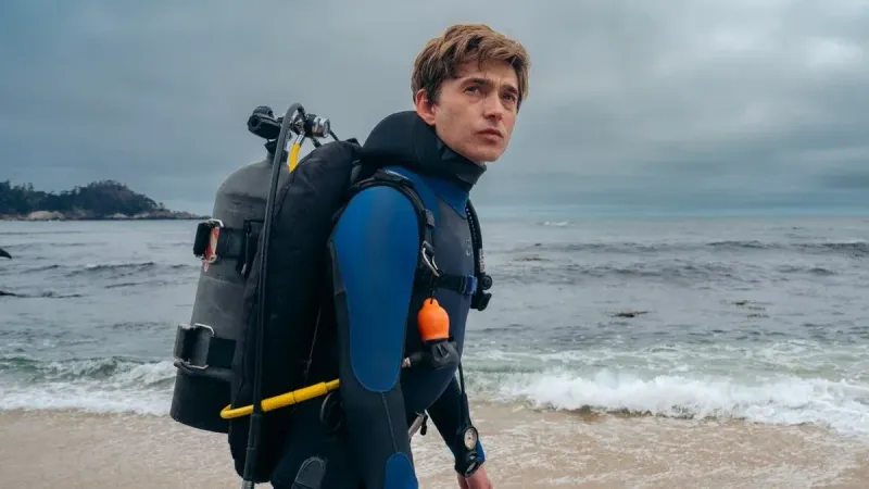 Image of Jay Gardiner (actor Austin Abrams) on a beach in SCUBA gear. From the 20th Century Studios movie "Whalefall."
