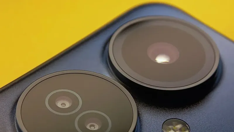 Primer plano extremo de lentes de cámara de teléfono inteligente con fondo amarillo vibrante, que muestra la tecnología moderna.