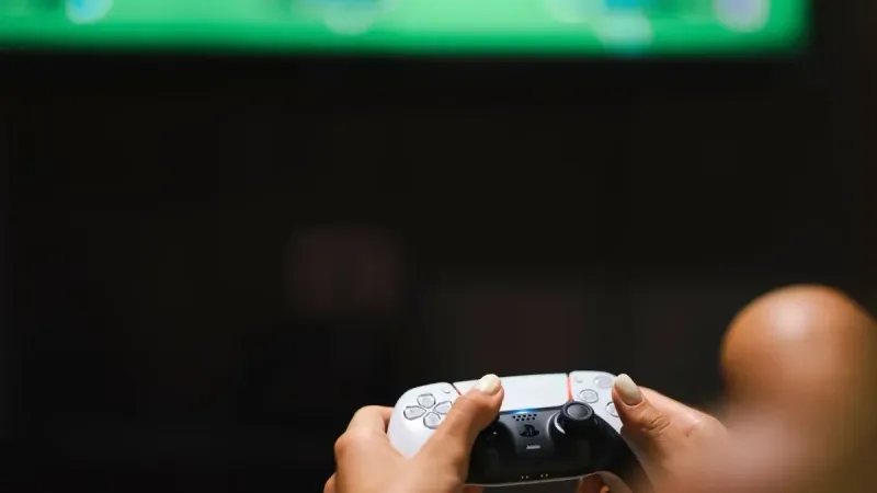 Close-up de manos sosteniendo un controlador de videojuego moderno mientras se juega.