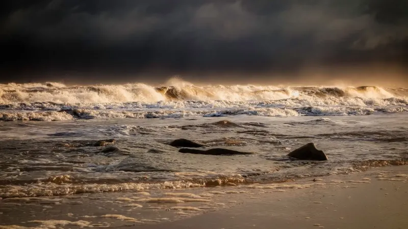 Vista cautivadora de poderosas olas del océano chocando en una costa escarpada bajo un cielo de mal humor.