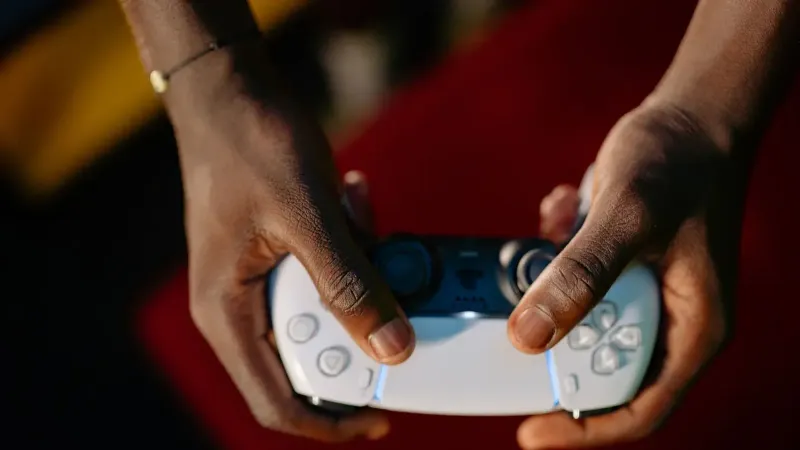 Vista de cerca de manos agarrando un controlador de juegos inalámbrico.